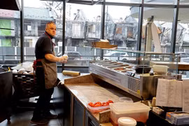 Một cửa hàng bán đồ ăn gần những ngôi nhà đổ nát ở Irpin, gần thủ đô Kiev, Ukraine, ngày 8/1/2023. (Ảnh: Yonhap/TTXVN)