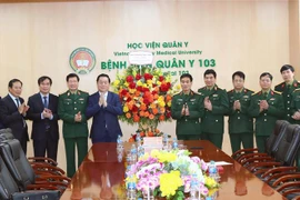 Trưởng Ban Tuyên giáo Trung ương Nguyễn Trọng Nghĩa chúc mừng tập thể Bệnh viện Quân y 103. (Ảnh: Trọng Đức/TTXVN)