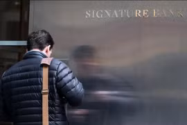 Một nhân viên ngân hàng đến trụ sở của Ngân hàng Signature Bank ở thành phố New York, Mỹ ngày 12/3. (Nguồn: Reuters)