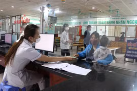 Bác sỹ Bệnh viện Sản-Nhi Bắc Ninh phát thẻ khách hàng cho bệnh nhân đến khám. (Ảnh: Thanh Thương/TTXVN)