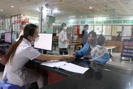 Bác sỹ Bệnh viện Sản-Nhi Bắc Ninh phát thẻ khách hàng cho bệnh nhân đến khám. (Ảnh: Thanh Thương/TTXVN)