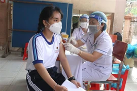 Tiêm vaccine phòng COVID-19 cho học sinh Trường Trung học cơ sở Lê Quý Đôn, thành phố Vĩnh Long. (Ảnh: Lê Thúy Hằng/TTXVN)