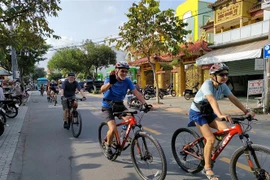 Du khách nước ngoài đi xe đạp trải nghiệm tại thành phố Bến Tre. (Ảnh: Huỳnh Phúc Hậu/TTXVN)