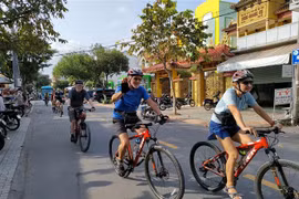 Du khách nước ngoài đi xe đạp trải nghiệm tại thành phố Bến Tre. (Ảnh: Huỳnh Phúc Hậu/TTXVN)