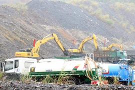 Xe khai thác, thu hồi đất đá thải mỏ phục vụ san lấp. (Ảnh: Văn Đức/TTXVN)