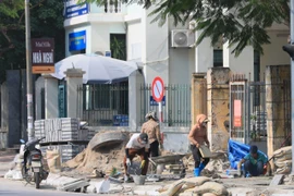 Công nhân xây dựng đang gấp rút hoàn thành vỉa hè trên phố Nguyễn Văn Huyên, quận Cầu Giấy sáng 26/11. (Ảnh: Hoàng Hiếu/TTXVN)