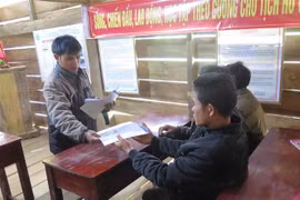 Cán bộ xã Măng Cành, huyện Kon Plông phát tài liệu tuyên truyền về động đất cho người dân. (Ảnh: Dư Toán/TTXVN)
