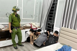 Các đối tượng bị bắt quả tang tụ tập sử dụng ma túy. (Ảnh: TTXVN)