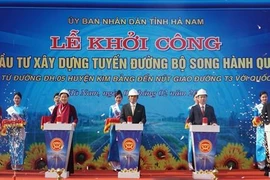 Các đại biểu bấm nút Khởi công Dự án đầu tư xây dựng tuyến đường bộ song hành Quốc lộ 21, tại xã Khả Phong, huyện Kim Bảng. (Ảnh: Thanh Tuấn/TTXVN)