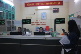 Người dân thực hiện các thủ tục hành chính tại bộ phận "Một cửa" phường Quán Thánh, quận Ba Đình. (Ảnh Mạnh Khánh/TTXVN)