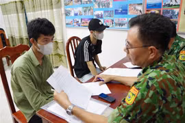 Lực lượng chức năng rà soát thông tin của các công dân vừa tiếp nhận từ lực lượng chức năng Campuchia. (Ảnh: Thanh Tân/TTXVN)