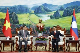 Tổng Bí thư, Chủ tịch nước Lào Thongloun Sisoulith tiếp thân mật đồng chí Lê Hoài Trung và đoàn. (Ảnh: Phạm Kiên/TTXVN)