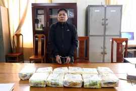 Đối tượng Phạm Văn Cường cùng tang vật bị bắt giữ. (Ảnh: TTXVN phát)