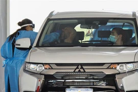 Nhân viên y tế lấy mẫu xét nghiệm COVID-19 cho người dân tại Perth, Australia. (Ảnh: AFP/TTXVN)