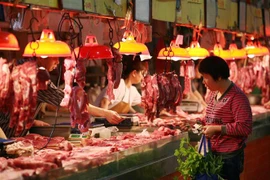 Người dân mua thực phẩm tại một khu chợ ở Quảng Châu, tỉnh Quảng Đông, Trung Quốc. (Ảnh: AFP/TTXVN)