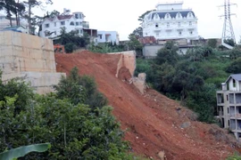 Bờ kè bêtông được đẩy sập đổ xuống theo phương án chủ động của chính quyền địa phương. (Ảnh Chu Quốc Hùng/TTXVN)