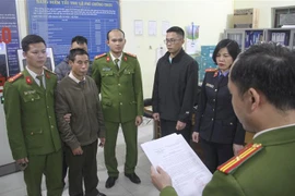  Cơ quan Cảnh sát điều tra đọc lệnh bắt bị can để tạm giam đối với Đinh Văn Cường. (Ảnh: TTXVN phát)