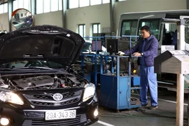 Nhân viên đăng kiểm thực hiện quy trình kiểm định xe. (Ảnh: Huy Hùng/TTXVN)
