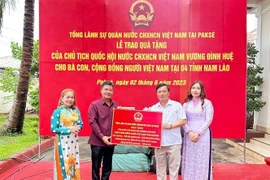 Đại diện Tổng Lãnh sự quán Việt Nam tại Pakse trao quà của Chủ tịch Quốc hội cho đại diện cộng đồng người Việt tại tỉnh Sekong. (Ảnh: TTXVN phát)