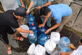 Người dân xếp hàng chờ lấy nước miễn phí tại Nhà máy nước Hạ Đình (địa chỉ, số 14 ngõ 192 phố Hạ Đình). (Ảnh: Thành Đạt/TTXVN)