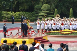 Thủ tướng Nguyễn Xuân Phúc và Thủ tướng Lào Thongloun Sisoulith nghe quân nhạc cử Quốc thiều hai nước. (Ảnh: Dương Giang/TTXVN)