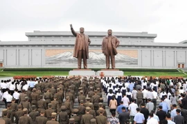 Người dân Triều Tiên dự lễ tưởng niệm tại tượng đài cố Lãnh tụ Kim Nhật Thành và Kim Jong-il nhân kỷ niệm 64 năm kết thúc Chiến tranh Triều Tiên ở thủ đô Bình Nhưỡng ngày 27/7. (Nguồn: YONHAP/TTXVN)