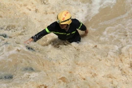 Lực lượng Cảnh sát phòng cháy chữa cháy tìm kiếm cháu Nguyễn Tấn Trường. (Ảnh: Sỹ Tuyên/TTXVN)