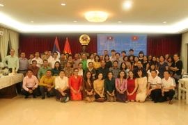 Cán bộ, nhân viên hai sứ quán chụp ảnh lưu niệm tại buổi giao lưu văn hóa. (Ảnh: Lê Hòa/Vietnam+)