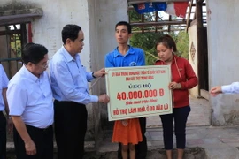 Ông Trần Thanh Mẫn trao tượng trưng 40 triệu đồng cho đình anh Nguyễn Khắc Thắng, Khối Hải Lam, Phường Nghi Hải, Thị xã Cửa Lò (Nghệ An). (Ảnh: Tá Chuyên/TTXVN) 