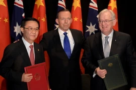 Bộ trưởng Thương mại Trung Quốc Cao Hổ Thành (trái), Thủ tướng Australia Tony Abbott (giữa) và Bộ trưởng Thương mại Australia Andrew Robb (phải) tại lễ ký kết. (Nguồn: AFP/TTXVN)