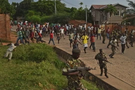 Binh sỹ Burundi cố gắng duy trì an ninh trong khi biểu tình diễn ra tại Musaga, ngoại ô thủ đô Bujumbura ngày 20/5. (Nguồn: AFP/TTXVN)