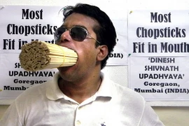 Thầy giáo Dinesh Upadhyaya đang ngậm 208 cây đũa trong miệng. (Nguồn: Daily Mail)