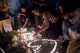 Người dân Thái Lan thắp nến bên ngoài đền thờ Erawan, tưởng niệm các nạn nhân vụ đánh bom. (Nguồn: AFP/TTXVN) 