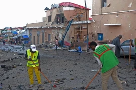 Nhân viên dọn dẹp sau các vụ tấn công. (Nguồn: AFP/TTXVN)