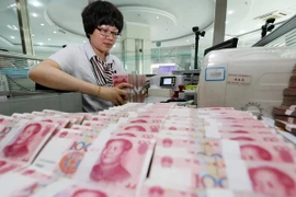 Kiểm tiền nhân dân tệ tại ngân hàng ở Liên Vận Cảng, tỉnh Giang Tô, Trung Quốc ngày 11/8. (Nguồn: THX/TTXVN) 