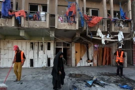 Nhân viên dọn dẹp sau vụ đánh bom ở quận Bayaa. (Nguồn: AFP/TTXVN) 