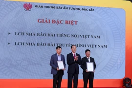 Chủ tịch nước Trần Đại Quang trao giải đặc biệt gian trưng bày ấn tượng, đặc sắc cho 2 đơn vị Đài truyền hình Việt Nam VTV và Đài tiếng nói Việt Nam VOV. (Ảnh: Minh Sơn/Vietnam+) 