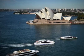 Khách du lịch đi thuyền tới tham quan khu vực Nhà hát Opera ở Sydney, Australia . (Nguồn: AFP/TTXVN)