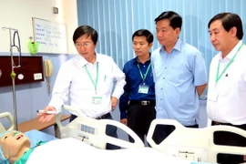 Bí thư Thành ủy Đinh La Thăng thăm quan phòng thực hành của trường. (Ảnh: Mạnh Linh/TTXVN)