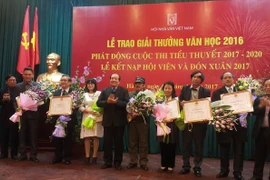 Nhà thơ Nguyễn Việt Chiến nhận giải thưởng Hội nhà văn. (Ảnh: Mỹ Bình/Vietnam+)