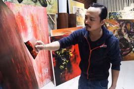 Họa sỹ Ngô Thanh Hùng sáng tác tranh tại nhà. (Ảnh: Văn Dũng/TTXVN)
