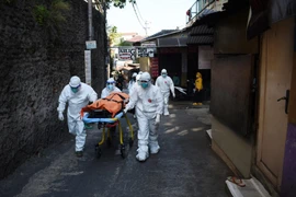 Chuyển cất thi thể bệnh nhân COVID-19 tại Bandung, Indonesia. (Ảnh: AFP/TTXVN)