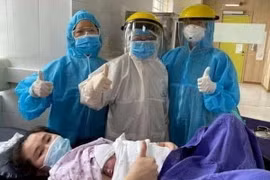 Một sản phụ cùng ekip bác sỹ đỡ đẻ tại khu cách ly. (Ảnh minh họa. TTXVN phát)