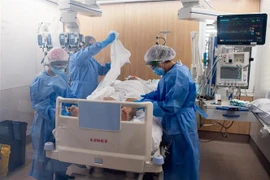 Nhân viên y tế điều trị cho bệnh nhân COVID-19 tại một bệnh viện ở Barcelona, Tây Ban Nha. (Ảnh: THX/TTXVN)