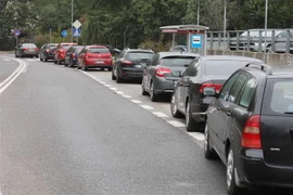 Các phương tiện xếp hàng tại một điểm xét nghiệm COVID-19 ở Ba Lan. (Ảnh: AFP/TTXVN)