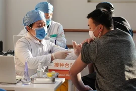 Nhân viên y tế tiêm chủng vắcxin ngừa COVID-19 cho người dân tại Bắc Kinh, Trung Quốc. (Ảnh: THX/TTXVN)
