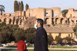 Người dân đeo khẩu trang phòng dịch COVID-19 khi di chuyển trên đường phố Rome. (Ảnh: THX/TTXVN)
