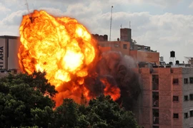Quả cầu lửa bốc lên khi toà nhà Al-Walid ở thành phố Gaza trúng rocket trong cuộc oanh tạc của máy bay Israel ngày 13/5/2021. (Ảnh: AFP/TTXVN)