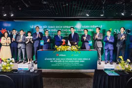 Đại diện lãnh đạo hai ngân hàng trao đổi văn kiện chứng nhận hoàn tất thương vụ phát hành cổ phiếu riêng lẻ. (Ảnh: PV/Vietnam+)