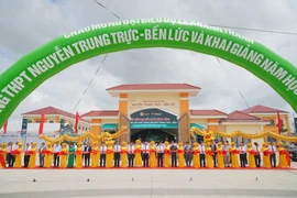 Đại diện Bộ ngành Trung ương và địa phương cùng nhà trường, đơn vị tài trợ thực hiện nghi lễ cắt băng khánh thành. (Ảnh: Vietnam+)